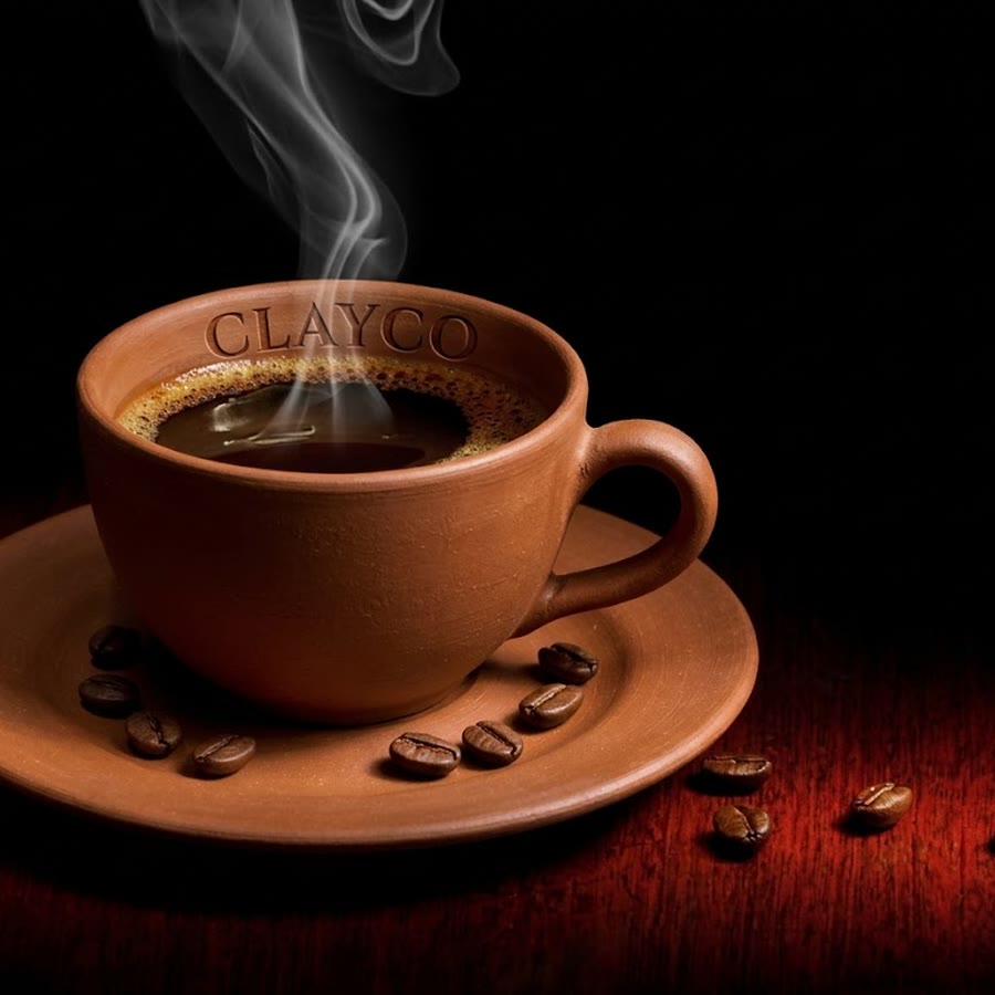 A CLAYCO terracotta cup of black coffee, steaming, with roasted beans on the saucer